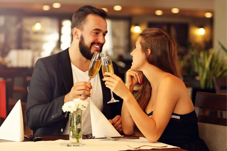 couple smiling driking wine in restaurant in NeverFail Dating